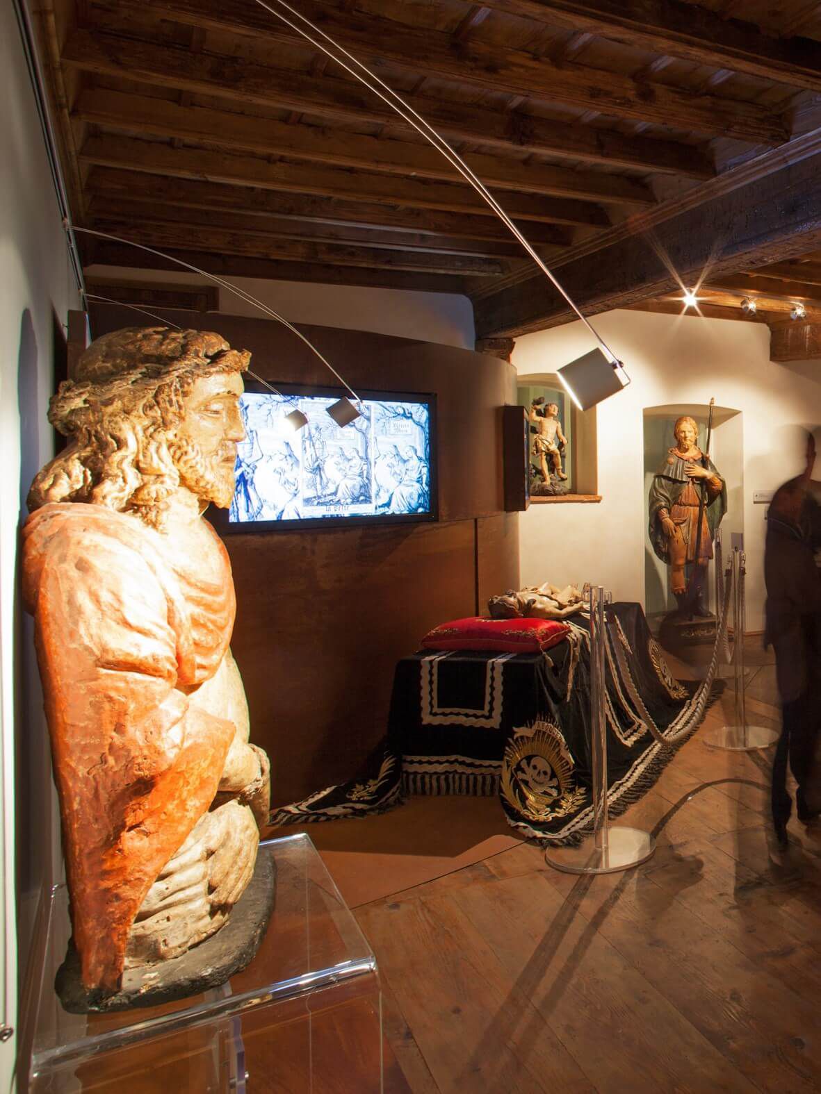 Sala di un museo con una statua lignea